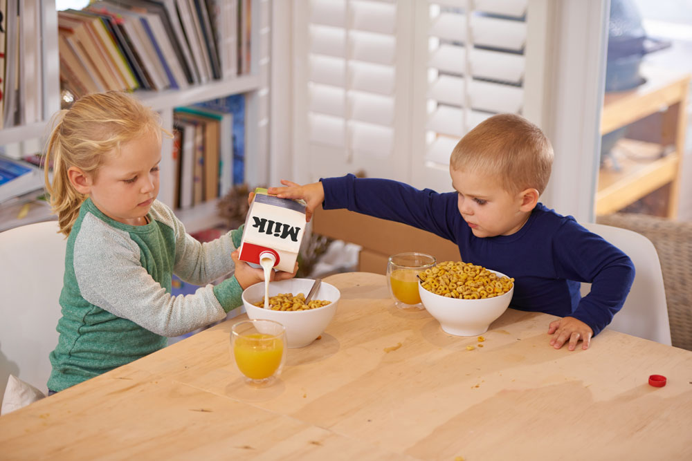 Familie spielt Lernspiel beim Frühstück