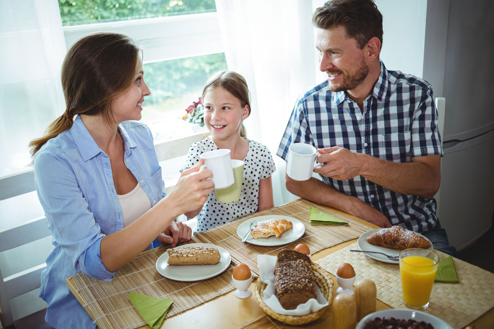 Eltern und Kind im Gespräch beim Frühstück