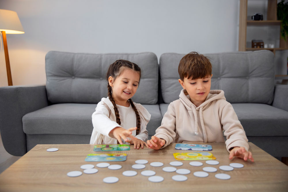 Kinder spielen gemeinsam am Tisch ein Lernspiel
