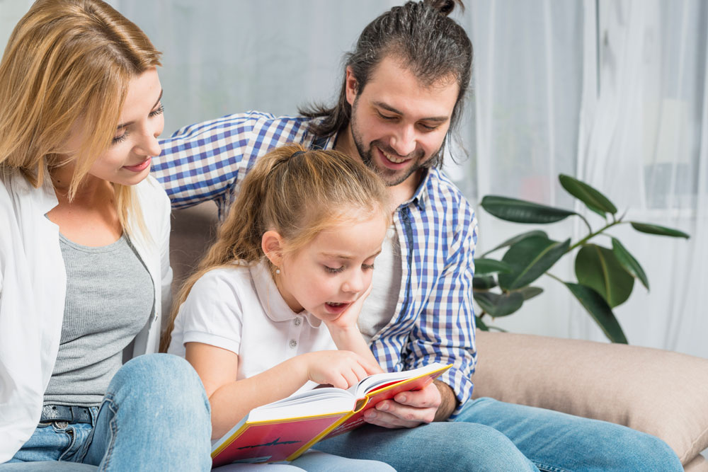 Eltern lesen gemeinsam mit ihrem Kind ein Buch