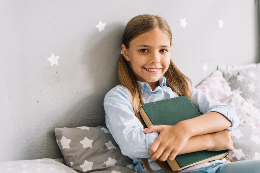 Kind freut sich über ein gelesenes Buch mit einer Auszeichnung