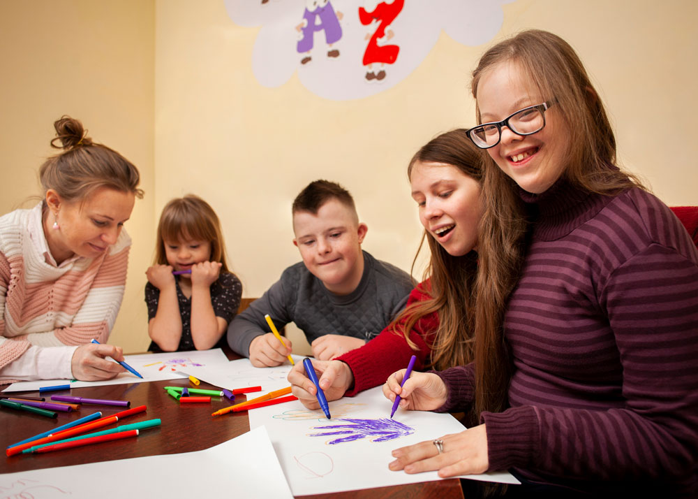 Lehrerin unterstützt Kinder beim gemeinsamen Lernen im Klassenzimmer