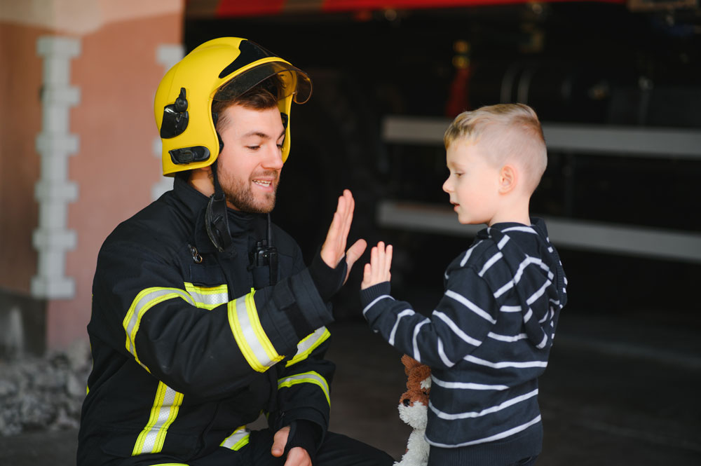 Kind und Ausbilder geben sich nach einer gelungenen Übung ein High-Five