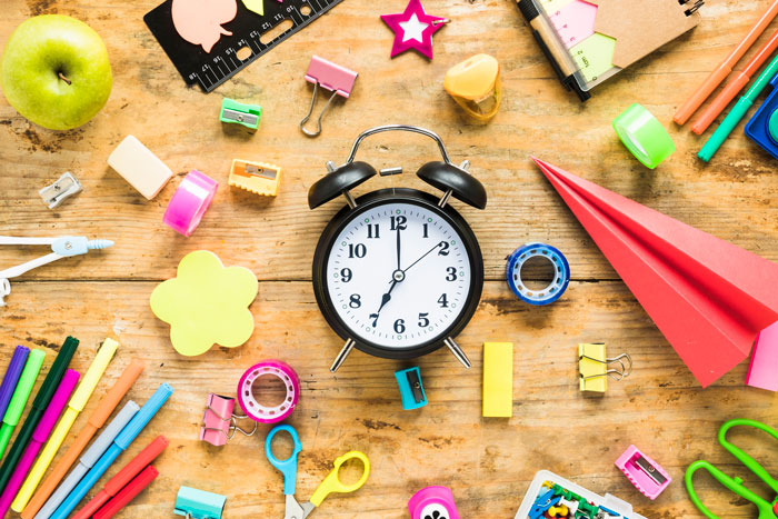 Schulmaterialien und Uhr – Planung der Ferien