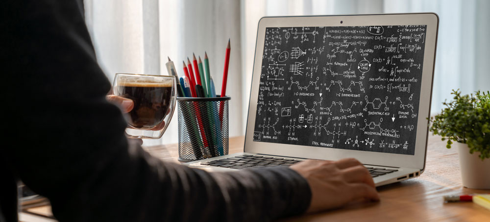 Online-Matheunterricht am Laptop mit komplexen Formeln und mathematischen Berechnungen auf dem Bildschirm.